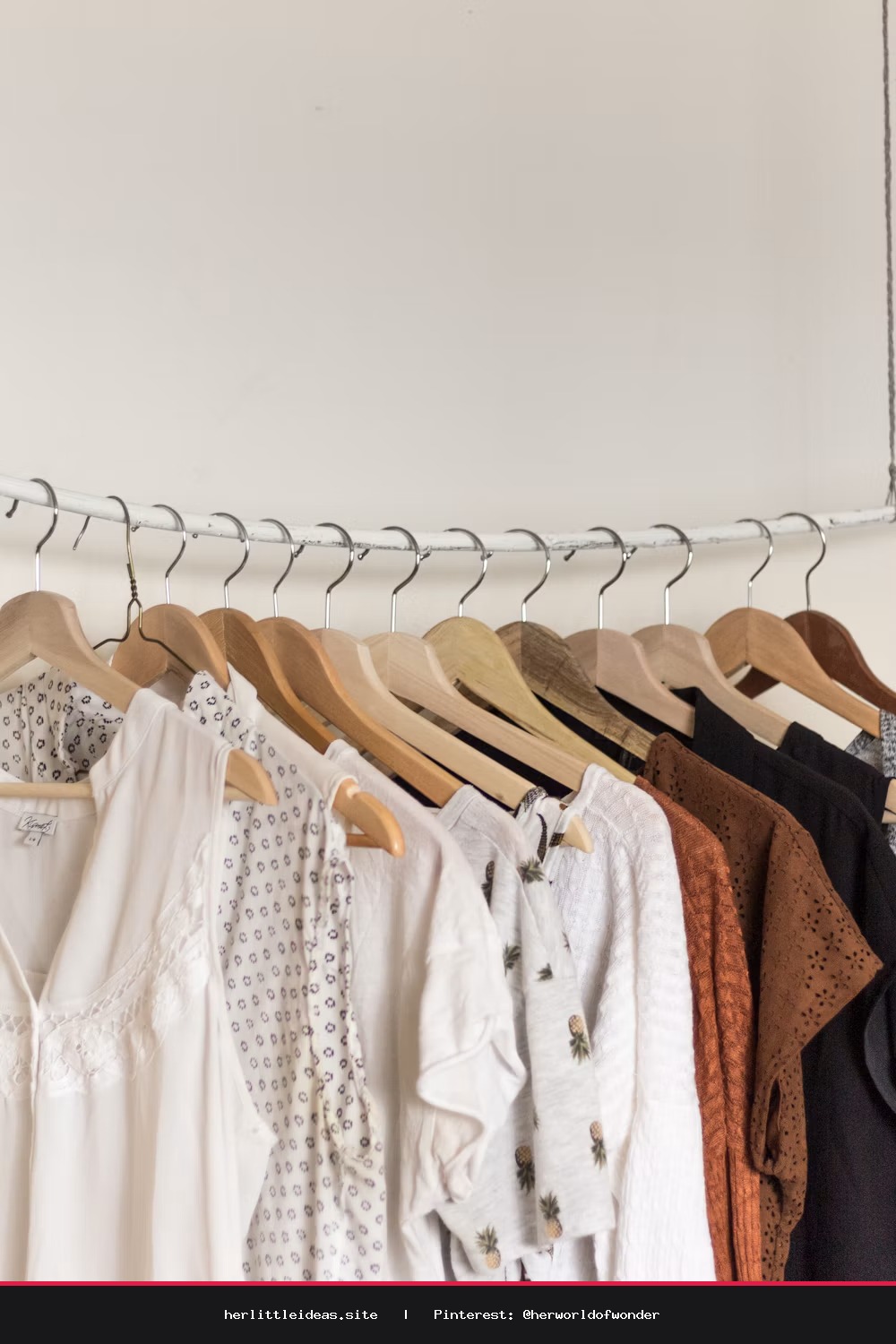 A woman in a relaxed, oversized white linen shirt and neutral linen trousers standing in a bright, sunlit room.