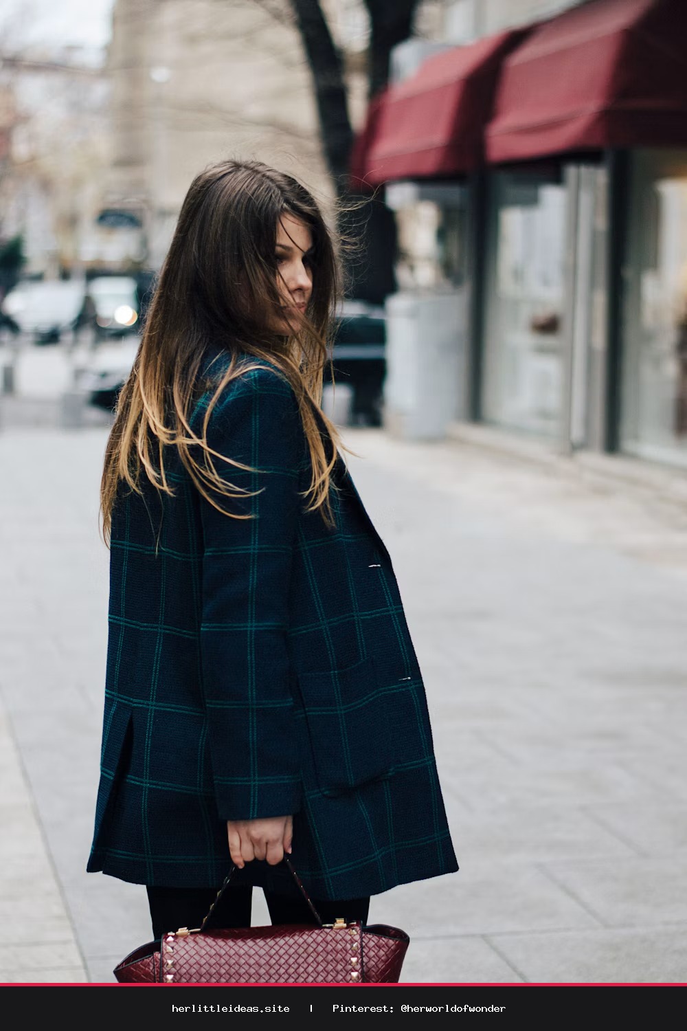 A woman wearing a crisp, oversized linen button-down shirt styled with neutral trousers in a bright, minimalist home.